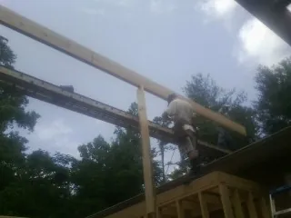 Carpenter setting a ridge beam over a new addition frame — Ice Dam Removal by Roofing Brothers in Evanston