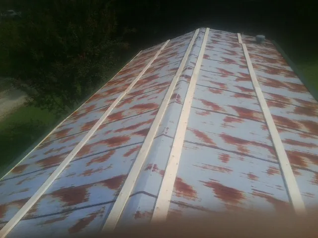 Rusted metal roof panels with new wood purlins before replacement — Storm Damage Roof Repair in Evanston by Roofing Brothers