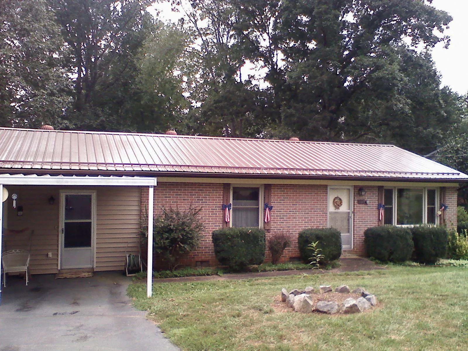 Bronze metal roof and carport on a brick ranch home — Roof Repair work by our crew in Evanston